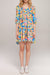 Woman wearing a colorful floral mini dress with scoop neck and tiered skirt from Johnny Was