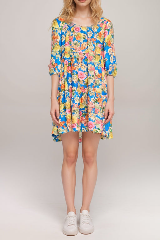 Woman wearing a colorful floral mini dress with scoop neck and tiered skirt from Johnny Was