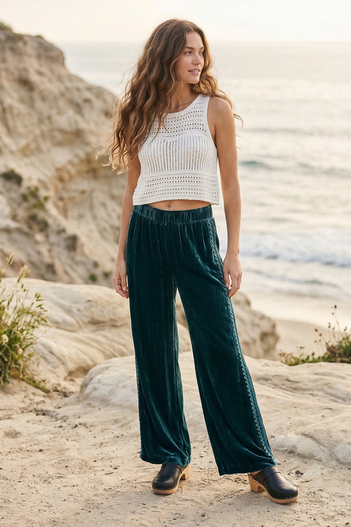 Woman wearing a teal velvet wide leg pants with side embroidery and pockets from Johnny Was