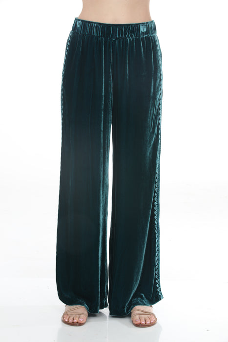 Woman wearing a teal velvet wide leg pants with side embroidery and pockets from Johnny Was