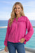 Woman wearing a bright pink blouse with lace trim and button down closure from Johnny Was