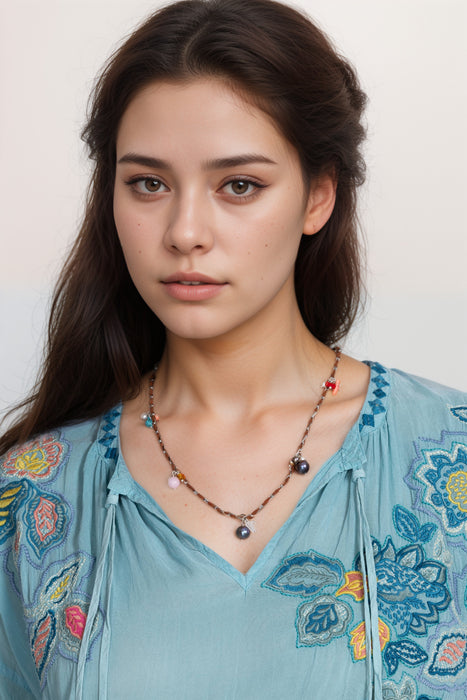 Woman wearing a necklace with pearls and colorful stones from Johnny Was