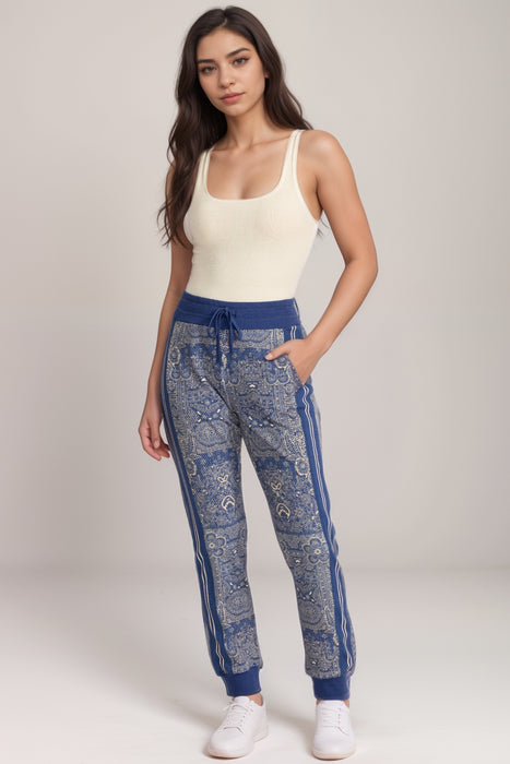 Woman wearing a blue denim lace patterned jogger pants with striped outseams