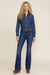 Woman wearing a medium blue rinse wash denim jeans with flared leg from Johnny Was
