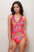 Woman wearing a red floral one piece swimsuit with deep v-neck and cross back straps from Johnny Was