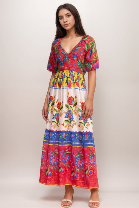 Woman wearing a colorful floral-printed maxi dress with v-neck and puff sleeves from Johnny Was