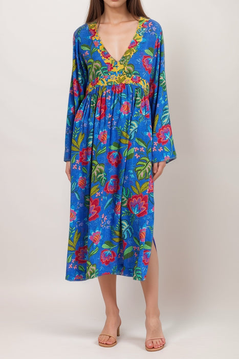 Woman wearing a blue floral-printed kaftan dress with v-neck and side slit from Johnny Was