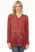 Woman wearing a red embroidered tunic top with long sleeves from Johnny Was