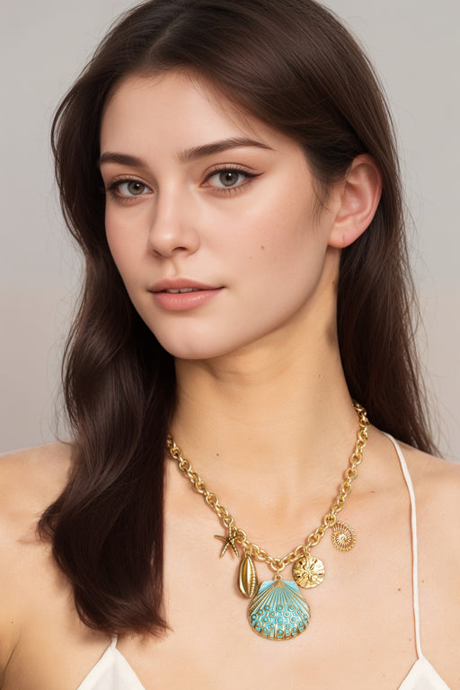 Woman wearing a gold tone chunky chain necklace with ocean-inspired charms from Johnny Was