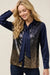 Woman wearing a sequin top with a neck tie and long-sleeves from Johnny Was