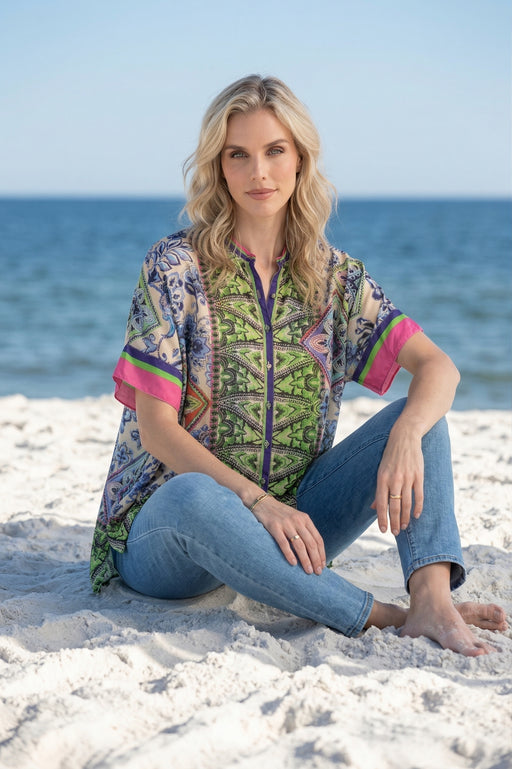 Woman wearing a colorful printed short sleeve shirt with button down front from Johnny Was