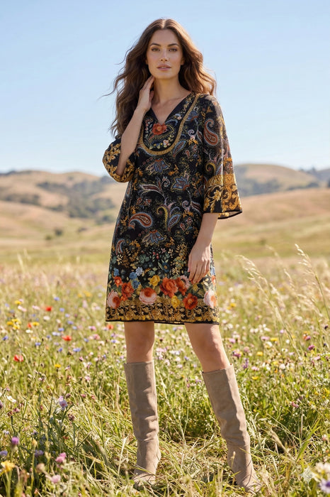 Woman wearing a black shift dress with colorful floral and paisley pattern from Johnny Was