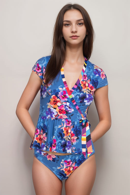 Woman wearing a blue floral-printed wrap tankini top with cap sleeves and side tie from Johnny Was