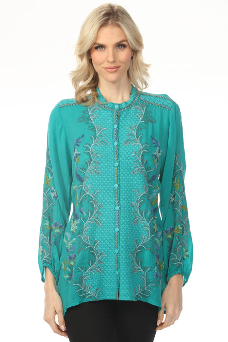 Woman wearing a teal embroidered blouse with button down front and puff sleeves from Johnny Was