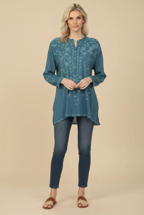 Woman wearing a teal embroidered tunic top with long sleeves from Johnny Was