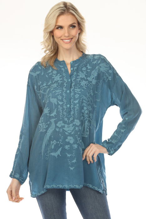Woman wearing a teal embroidered tunic top with long sleeves from Johnny Was