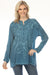 Woman wearing a teal embroidered tunic top with long sleeves from Johnny Was