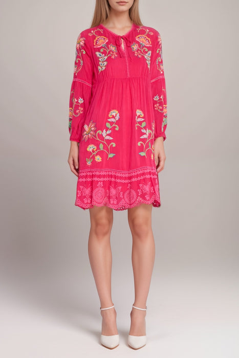 Woman wearing a pink floral-embroidered mini dress with scallop hem from Johnny Was
