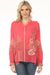 Woman wearing a coral long sleeve blouse with floral embroidery and button front from Johnny Was
