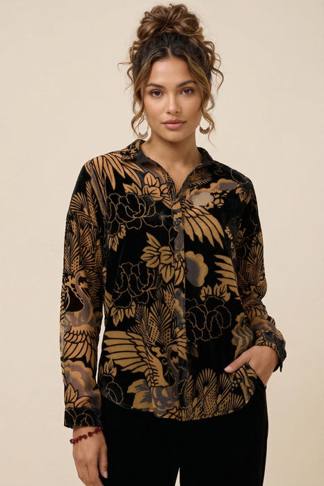 Woman wearing a black floral patterned semi-sheer shirt with long sleeves from Johnny Was