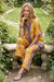 Woman wearing a yellow floral-printed short sleeve tunic top with button front and mandarin collar from Johnny Was