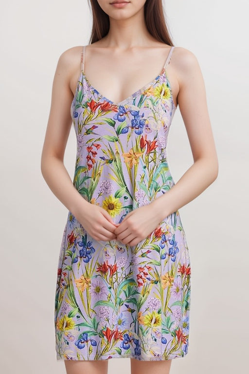Woman wearing a purple cami sleep dress with colorful floral print and adjustable spaghetti straps from Johnny Was