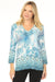 Woman wearing a blue v-neck t-shirt with floral pattern and 3/4 sleeves from Johnny Was