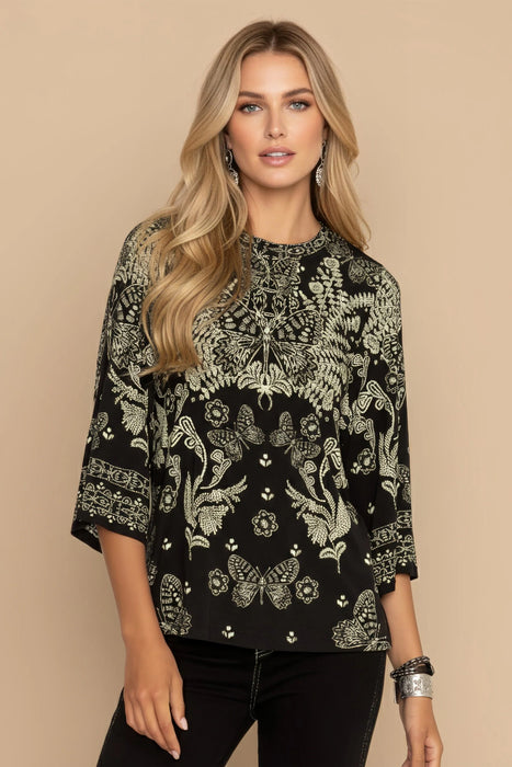 Woman wearing a black printed top with crew neck and 3/4 sleeves from Johnny Was