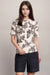 Woman wearing a black and white fitted t-shirt with floral and butterfly prints from Johnny Was