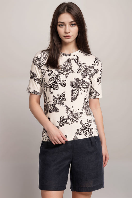 Woman wearing a black and white fitted t-shirt with floral and butterfly prints from Johnny Was
