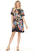 Woman wearing a colorful floral printed shift dress with short flutter sleeves