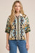Woman wearing a patterned shirt with button front and 3/4 sleeves from Johnny Was