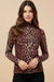 Woman wearing a leopard print long-sleeve fitted top with mock neckline from Johnny Was