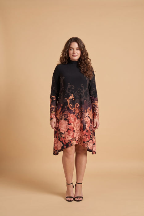A woman modeling a long-sleeve mock-neck dress with a black upper section and a floral gradient pattern in shades of orange, pink, and red on a black base, set against a solid beige studio background.