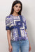 Woman wearing a blue and white floral patterned top with crew neck and short sleeves from Johnny Was