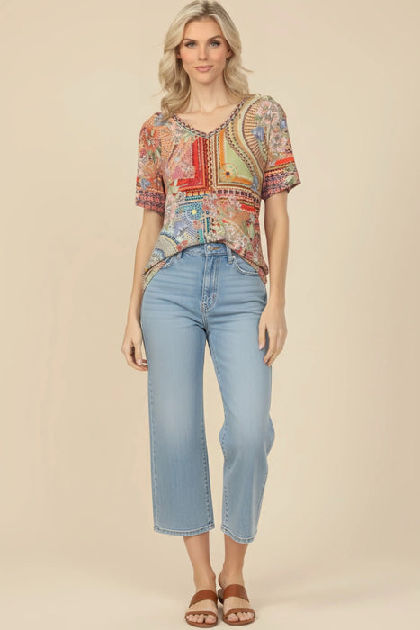 Woman wearing a colorful mosaic tile patterned tee with v-neck and short sleeves from Johnny Was