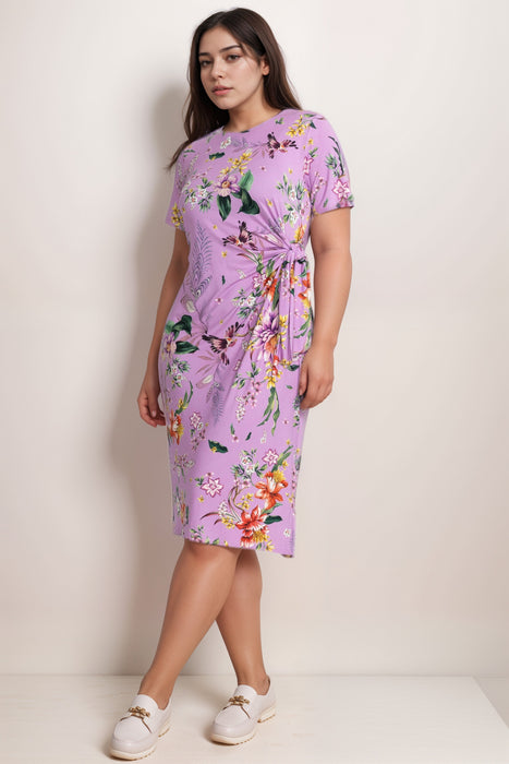 Woman wearing a purple floral midi dress with side tie detail from Johnny Was