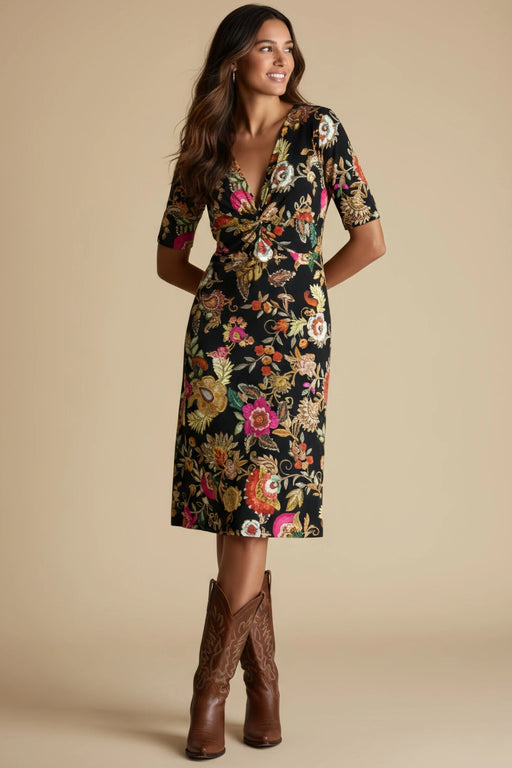 Woman wearing a black floral midi dress with v-neck and twist front detail from Johnny Was