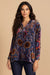 Woman wearing a button-down shirt with floral and geometric burnout pattern from Johnny Was