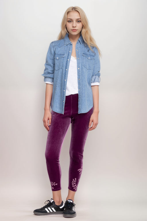 Woman wearing a purple velvet legging with tonal floral embroideries and cropped length from Johnny Was