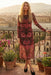 Woman wearing a red floral mesh midi dress with long sleeves from Johnny Was