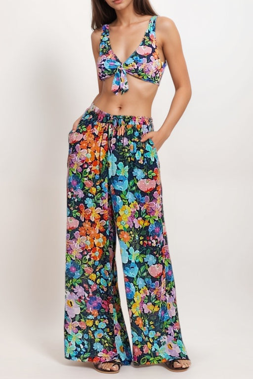 Woman wearing a colorful floral wide leg cover up pant with side pockets from Johnny Was