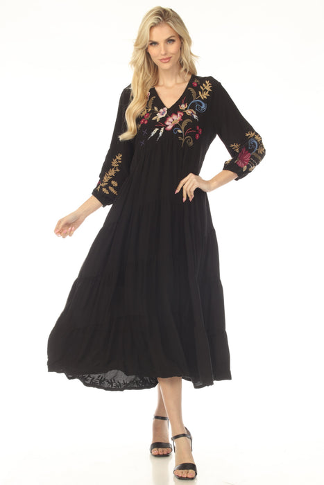 Woman wearing a black dress with floral embroidery and tiered maxi skirt from Johnny Was