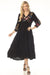 Woman wearing a black dress with floral embroidery and tiered maxi skirt from Johnny Was