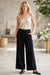 Woman wearing a black velvet corduroy pants with side pockets and wide leg from Johnny Was