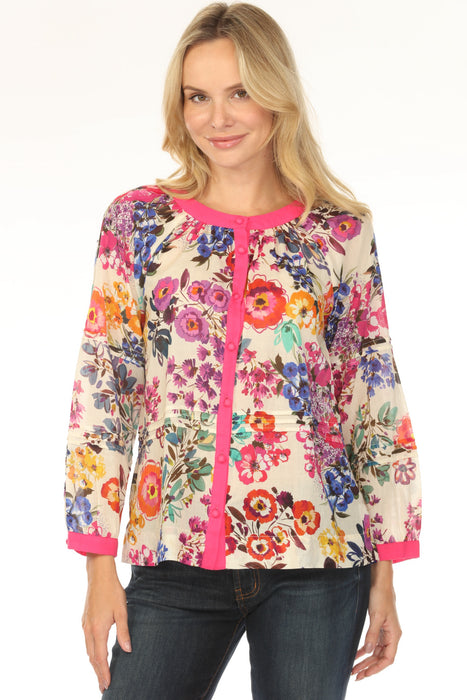 Woman wearing a colorful floral-printed blouse with pink trim and pintuck detail from Johnny Was