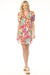 Woman wearing a colorful floral-printed tunic dress with contrast piping and puff sleeves from Johnny Was
