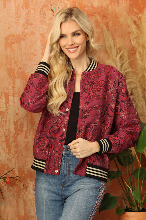 Woman wearing a red floral patterned bomber jacket with striped trims from Johnny Was