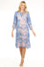 Woman wearing a blue midi kaftan dress with floral scroll pattern and kimono sleeves from Johnny Was