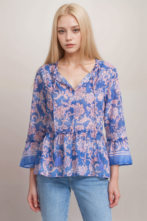 Woman wearing a floral scroll patterned blouse with ruffles and split v-neck with tie from Johnny Was